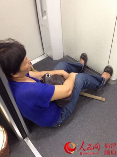 她太困了，旁人为她也许不雅的睡姿让出一个空间。林长生 摄