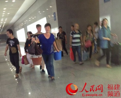 动车还没到站就自动醒来的她，又精神满满地挑着蛋走出厦门北站。林长生 摄