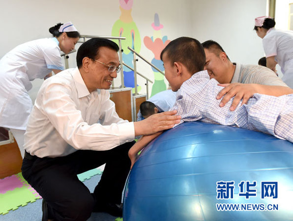 这是李克强与进行康复训练的患儿交谈。 新华社记者马占成摄