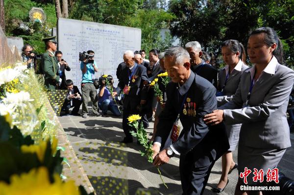 6月12日，参加公祭活动的老兵向中国远征军抗日将士纪念碑献花。当日，2014“中国远征军抗日阵亡将士”公祭活动在云南腾冲举行，从缅甸寻取的中国远征军抗日阵亡将士部分遗骸，归葬在腾冲国殇墓园中国远征军抗日阵亡将士墓。中新社发 刘冉阳 摄