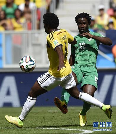 6月19日，科特迪瓦队球员维?博尼（右）与对方球员拼抢。当日，在巴西首都巴西利亚马内?加林查国家体育场进行的2014年巴西世界杯小组赛C组比赛中，哥伦比亚队对阵科特迪瓦队。 新华社记者戚恒摄