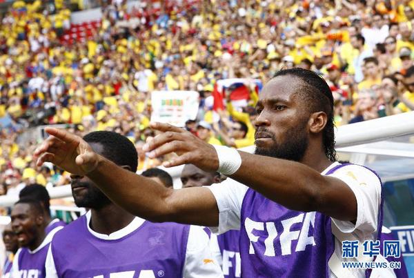 6月19日，未能首发上场的科特迪瓦队球员德罗巴（右）为场上队友加油助威。当日，在巴西首都巴西利亚马内?加林查国家体育场进行的2014年巴西世界杯小组赛C组比赛中，哥伦比亚队对阵科特迪瓦队。 新华社记者刘彬摄