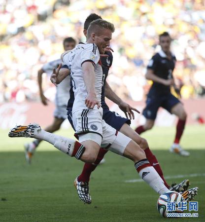 7月4日，德国队球员许尔勒（前）起脚传中。当日，在巴西里约热内卢马拉卡纳大球场进行的2014年巴西世界杯四分之一决赛中，德国队以1比0战胜法国队，晋级四强。　　新华社记者王丽莉摄