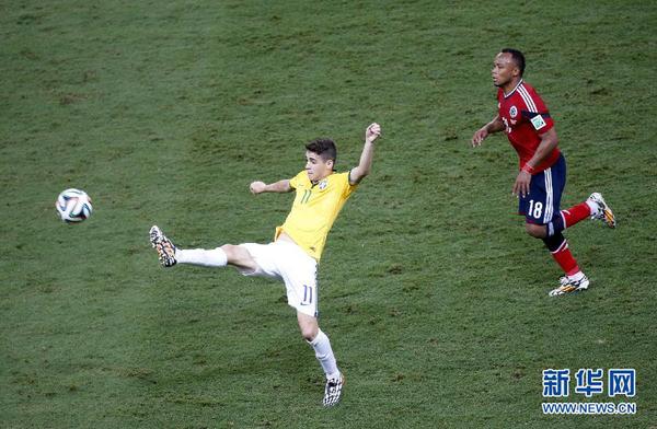 7月4日，巴西队球员奥斯卡（左）在比赛中。当日，在巴西福塔莱萨卡斯特洛竞技场进行的2014年巴西世界杯四分之一决赛中，巴西队对阵哥伦比亚队。 　　新华社记者廖宇杰摄