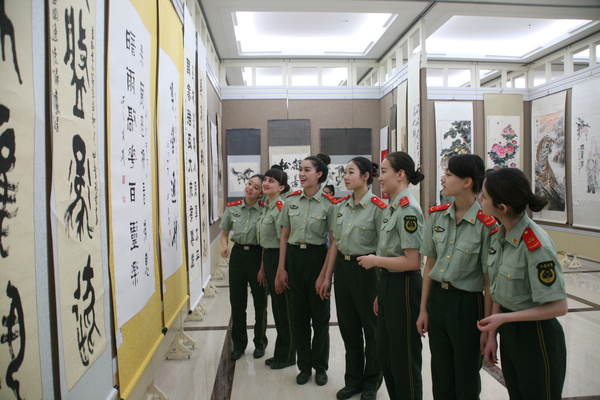 援疆捐赠暨书画创作展等系列文化公益活动在乌市举行。6图为部队战士在认真观看书画展览。