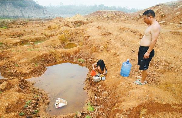 7月30日，大河报记者奔赴严重干旱的平顶山市宝丰县，看到旱情如同烈火，抗旱十万火急。父女俩，在已经枯竭的上李庄水库库底取水，这里离他们的家两公里。 记者 李红汛 实习生 余文龙 文 记者 平伟 实习生 高阳 摄影 图片来源：大河网