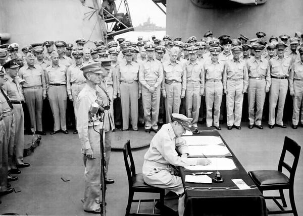 图为麦克阿瑟在受降书上签字。