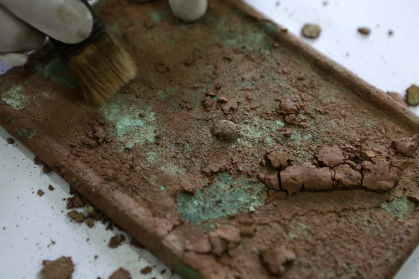 8月12日，工作人员在重庆市大足石刻研究院清理大足区城东的宋代墓葬群出土的铜镜。