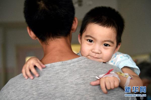 8月20日，在太原市山西省儿童医院病房内，“喂食爸爸”王志华抱着逐渐康复的小可然。