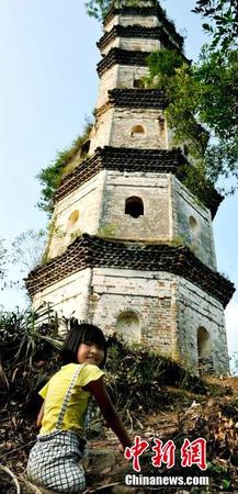 图为8月25日，“无腿女孩”蒋张子怡美丽的笑容与坚挺400多年的半边古塔相应成趣。卓忠伟 摄