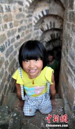 图为8月25日，“无腿女孩”蒋张子怡执意要自己亲手攀爬上塔。卓忠伟 摄