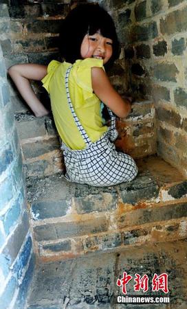 图为8月25日，“无腿女孩”蒋张子怡执意要自己亲手攀爬上塔。卓忠伟 摄1