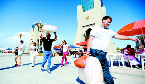 中哈霍尔果斯国际边境贸易区，中哈两边的生意堪称红火。哈萨克斯坦的游客购买中国的商品后，连提带扛地把货物运走。