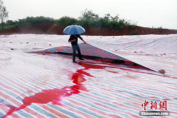 2014年9月15日，河南洛阳汝阳县马兰河因为污染变成一条“红河”，“红水”顺着山坡一直流到山下，而“红水”的源头正是附近一山顶的染料厂残留处理池。图为山顶涂料厂未处理的残渣被塑料布覆盖，因多日降雨，染红的雨水从山流下。