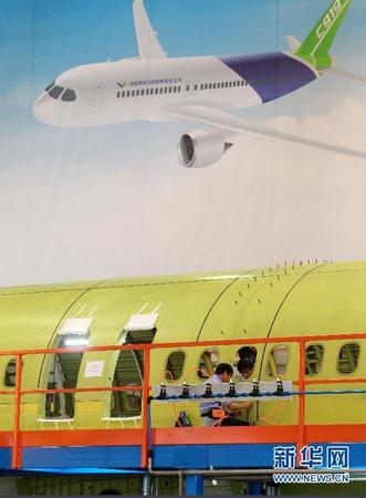 　 9月19日，技术人员对接C919首架机的机体。当日，C919国产大型客机首架机在中国商飞公司新落成的总装制造中心正式开始机体对接，这标志着C919大型客机研制项目全面进入结构总装攻坚阶段。项目力争年底完成首架机机体结构对接，2015年底实现首飞。新华社记者丁汀 摄