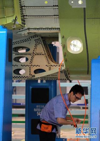 　 9月19日，技术人员在C919机体对合装配线上工作。当日，C919国产大型客机首架机在中国商飞公司新落成的总装制造中心正式开始机体对接，这标志着C919大型客机研制项目全面进入结构总装攻坚阶段。项目力争年底完成首架机机体结构对接，2015年底实现首飞。新华社记者裴鑫 摄