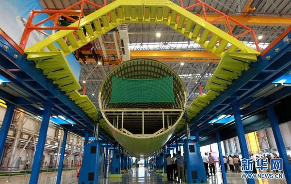 这是在装配线上进行对接的C919首架机的机体（9月19日摄）。9月19日，C919国产大型客机首架机在中国商飞公司新落成的总装制造中心正式开始机体对接，这标志着C919大型客机研制项目全面进入结构总装攻坚阶段。项目力争年底完成首架机机体结构对接，2015年底实现首飞。新华社记者裴鑫 摄