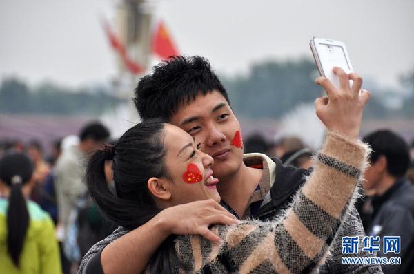 10月1日，一对年轻人在天安门广场自拍。