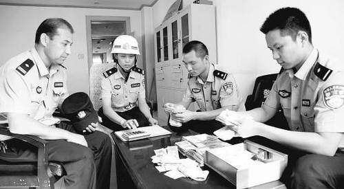 　8月6日晚上8点，司马义（左一）和督查组的同事清点爱心款。崔岱摄