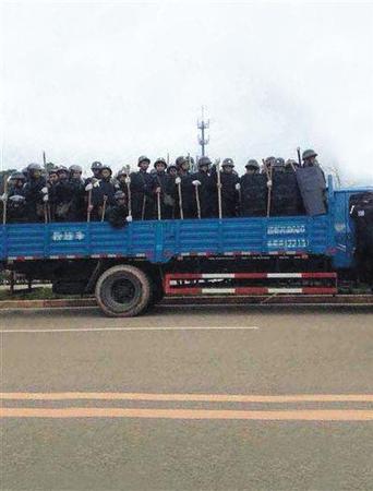 现场头戴钢盔手持木棍的人员。