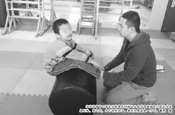 海淀培智中心学校的康复老师滕飞正在指导脑瘫患儿做运动康复训练，滕飞说，对于特殊孩子，教育和康复缺一不可。曹燕 摄