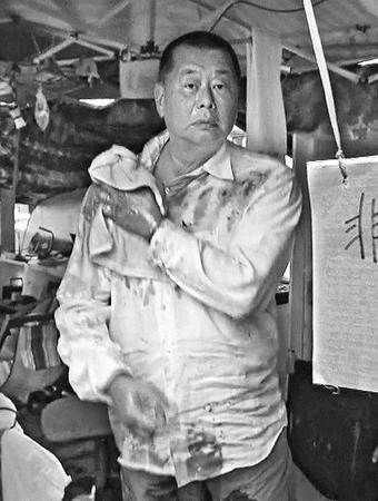 图片说明：黎智英12日被愤怒民众泼污物。