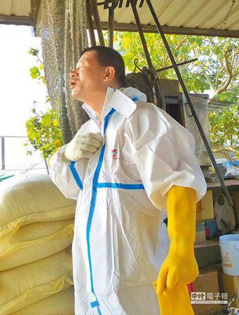 清洁队员闷在防疫衣里多时，中场休息卸下装备大口呼吸。《中国时报》