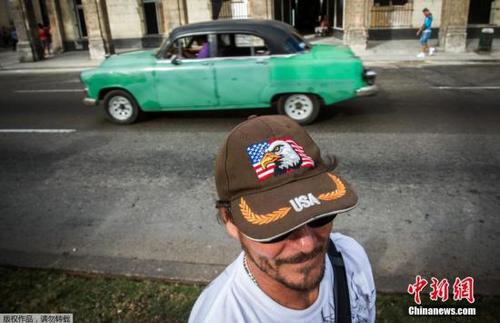 图为当地时间2月3日，古巴首都哈瓦那，一个行人头戴印有美国国旗的帽子行走在街头。
