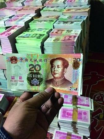 在印刷厂车间内，仿制市面流通的第五版人民币的冥币成堆摆放