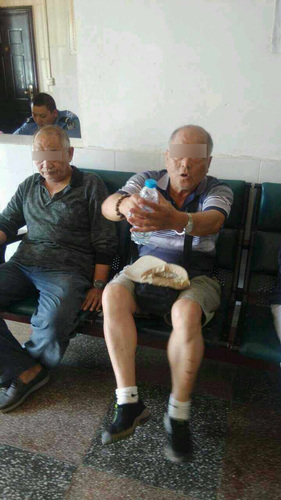 打人的两男子在派出所做笔录。