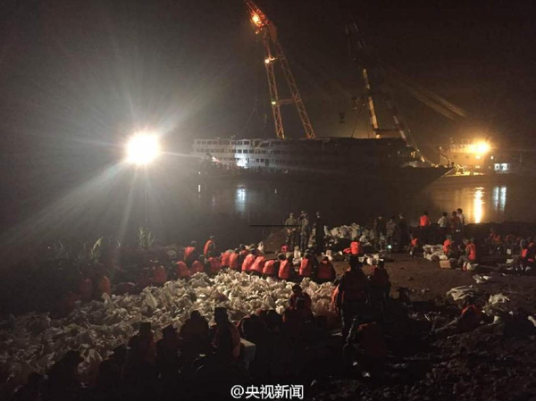 6月9日晚，打捞出水的“东方之星”发生一定程度倾斜，船体向左侧倾斜80厘米。武警官兵现场装沙袋配重调平，将沙袋运上东方之星右侧甲板放置，调平后将等待拖行至安全水域。据了解倾斜原因或与减载、水流等有关。央视记者刘峰 张宗尧 欧阳干湘 图片来源：央视新闻官方微博1