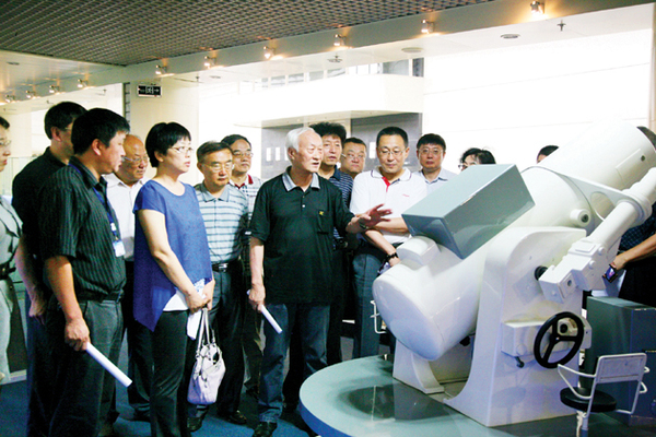 委员们实地了解电影经纬仪有关情况。    本报记者 高嵩 摄