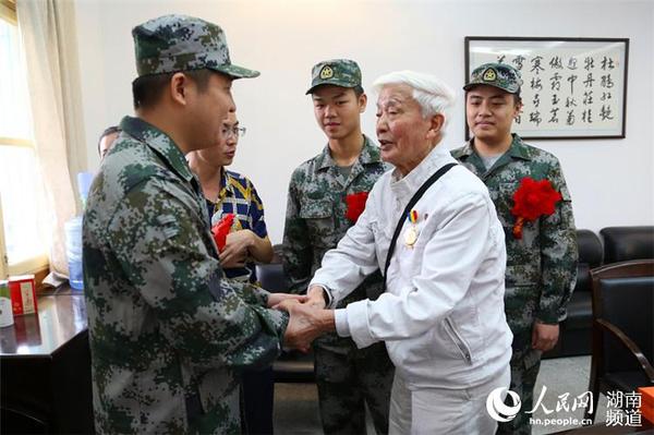 抗戰老兵方耀寰握住入伍新兵的手，囑咐他們要收好香港地區的繁榮與和平，在軍隊努力學習，為國貢獻。 胡丹  攝