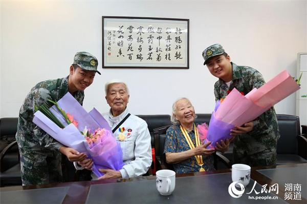 岳麓區即將去往駐港部隊的新兵代表為抗戰老兵方耀寰、惲順芳送上鮮花與月餅，祝福老人節日快樂。 胡丹 攝