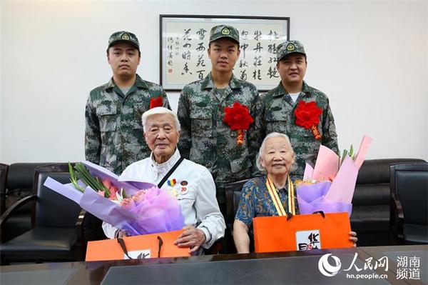 9月8日，岳麓區即將去往駐港部隊的新兵代表為抗戰老兵方耀寰、惲順芳送上鮮花與月餅，祝福老人節日快樂。 胡丹 攝