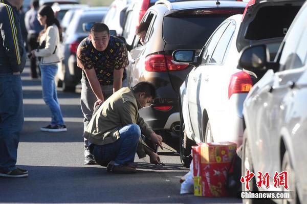 10月1日，十一黄金周第一天，受出京自驾游玩车辆增多影响，京沪高速泗村店路段严重拥堵。图为一位司机正在换轮胎。小可 摄 图片来源 CFP视觉中国