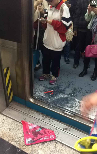 地铁到站后，网友拍摄的被砸车门的玻璃渣
