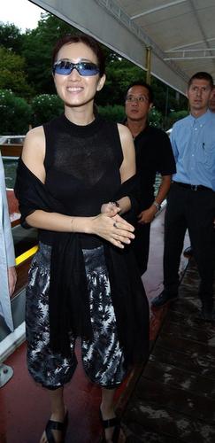 图中着黑色上衣的男子（中间）是巩俐的经纪人曾敬超