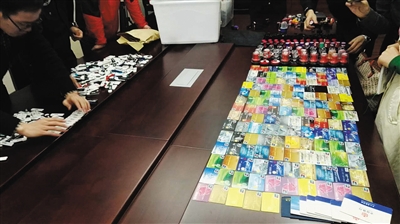 　10月30日，兰溪县公安局，浙江金华“9·16”专案组民警展示大量的银行卡、公章及U盾等地下钱庄作案工具。 警方供图