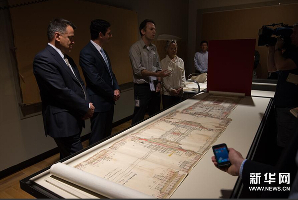 12月8日，在位于澳大利亚堪培拉的澳大利亚国家图书馆展厅，策展人内森·沃利博士（左三）向媒体介绍中国国家图书馆出借的展品——《大清门至坤宁宫中一路立样糙底》。