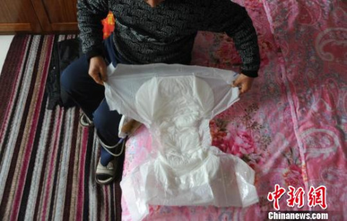 因为尿管会漏，申建军（化名）需要时常带着大号成人纸尿裤。　胡健　摄