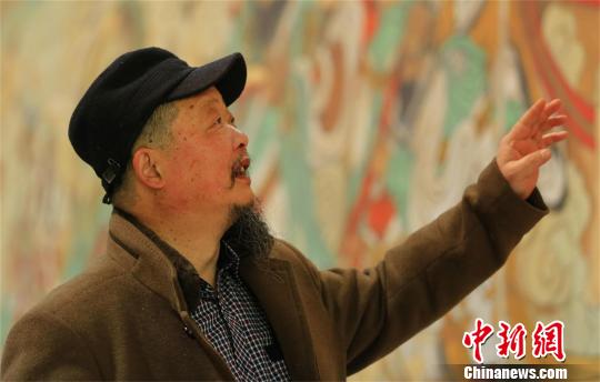 刘庸之在向人介绍自己的壁画 涂玉国 摄