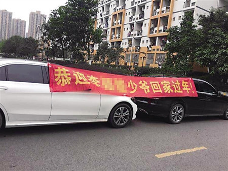 两辆奔驰校门口拉横幅“恭迎少爷回家过年”（图）