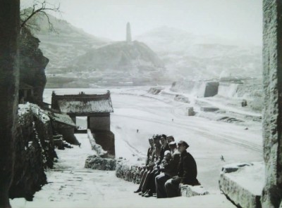 徐佛观坐在延安交际处，远处就是宝塔山。