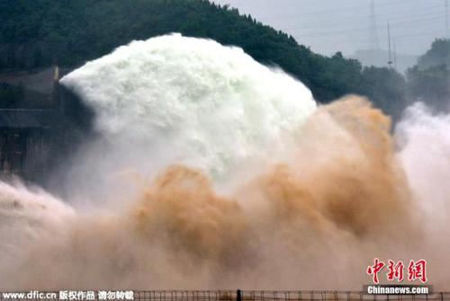 资料图：2015年6月29日，游客在黄河小浪底水利枢纽工程出水口观看泄水的壮观场景。当日，2015年黄河小浪底调水调沙开始。图为游客在黄河小浪底水利枢纽工程观看飞瀑景观。图片来源：东方IC 版权作品 请勿转载