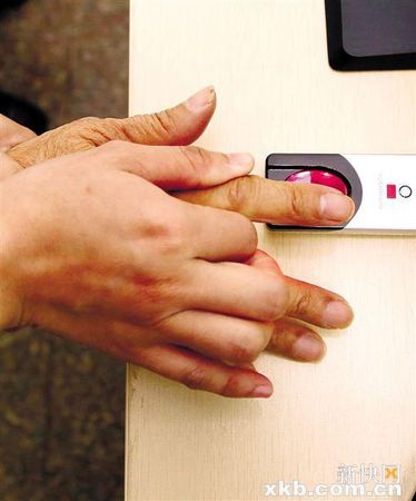 工作人员帮助老人按手印。