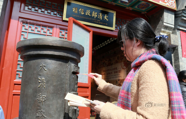 2016年03月20日，北京，因装修停业一个多月的大清邮政信柜在什刹海烟袋斜街重张开业。重张后的信柜除保留原有邮政业务外，还新增邮驿博物馆，为游客呈现从商周时期到清代的邮驿发展历程。游客在大清邮政信柜门前投寄明信片。