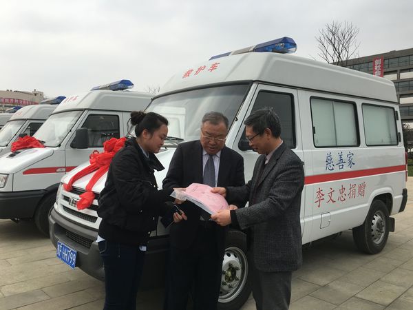 李文忠（中）与毕节市卫计委工作人员办理巡诊车交付使用的手续，右为毕节市卫计委主任邓韬。