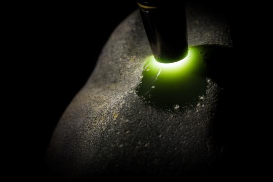 原石绿色浓烈而古雅，打光后呈现出温暖的黄绿色调。