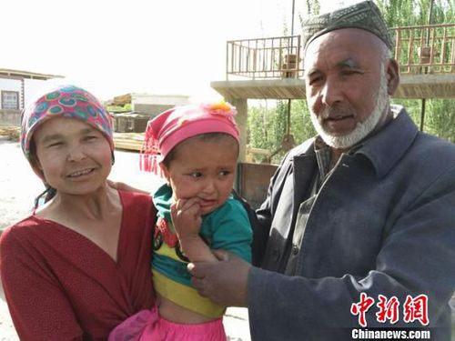 妈妈抱着被救的孩子与老人合影?！⊙铈面?摄